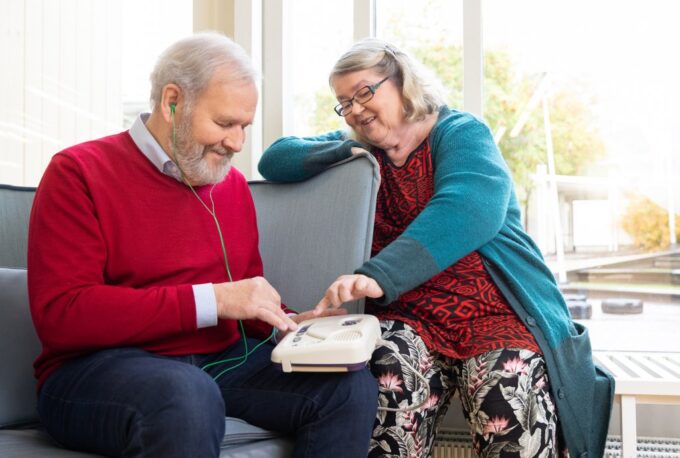 Två personer lyssnar på en talbok från Tillgänglighetsbiblioteket Celia med en Daisy-spelare.